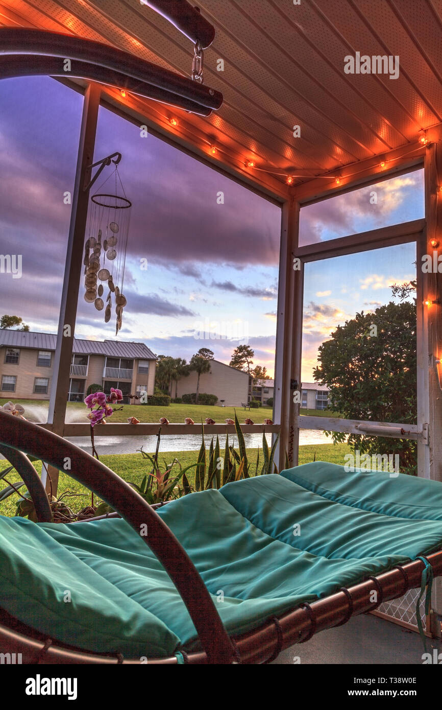 Swinging Lounge Chair On A Lanai At Sunset As It Overlooks A