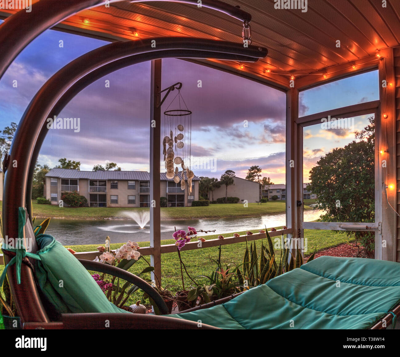 Swinging Lounge Chair On A Lanai At Sunset As It Overlooks A