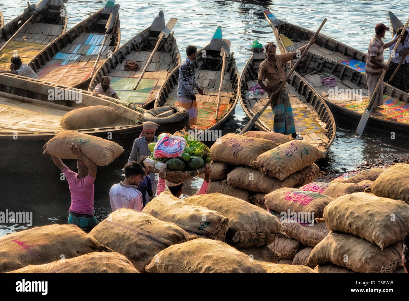 Loading sacks onto ferry boats on Buriganga River at Sadarghat (City Wharf), Dhaka River Port, Dhaka, Bangladesh Stock Photo