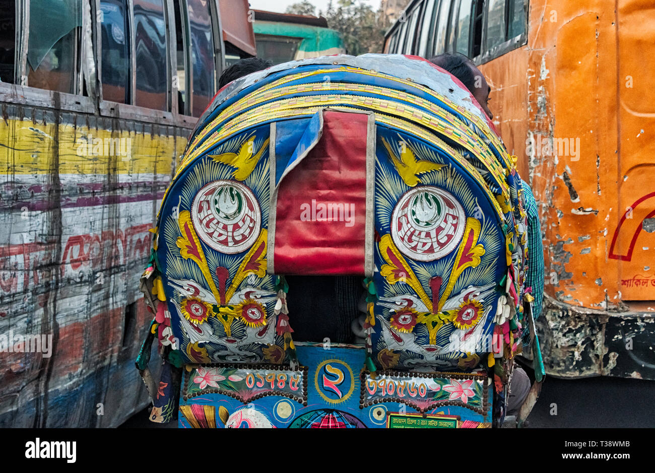 Colorful painted rickshaws and old scratched buses on the street, Dhaka, Bangladesh Stock Photo
