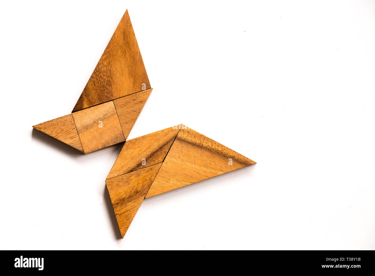 Wooden tangram puzzle in butterfly shape on white background Stock