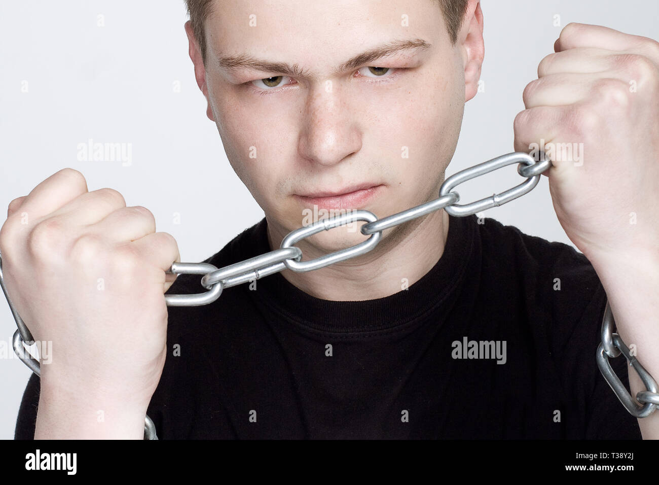 Man in chain shackles on graybackground Stock Photo Alamy
