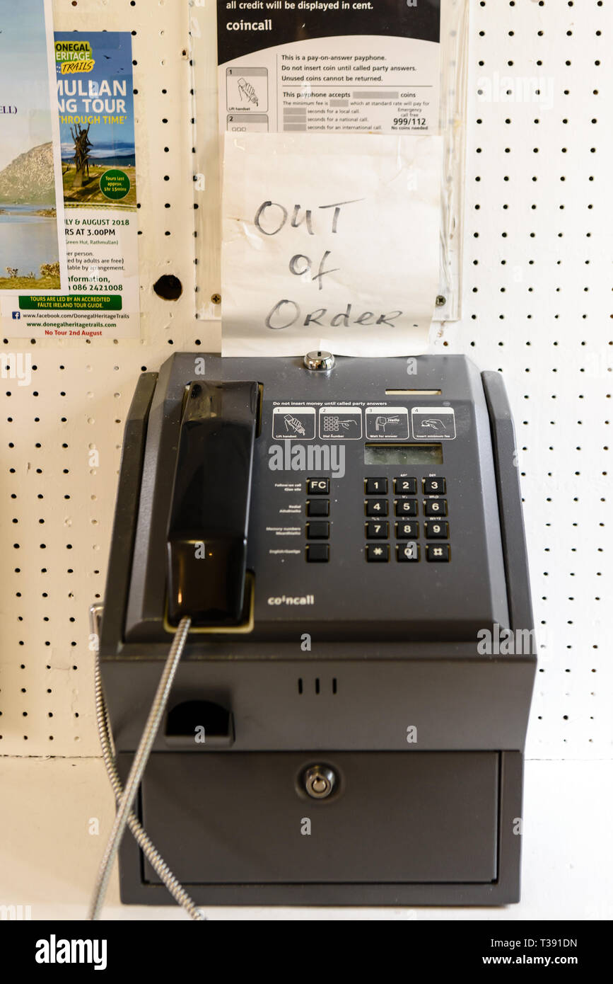 Public telephone with a sign saying 'Out of Order'. Stock Photo