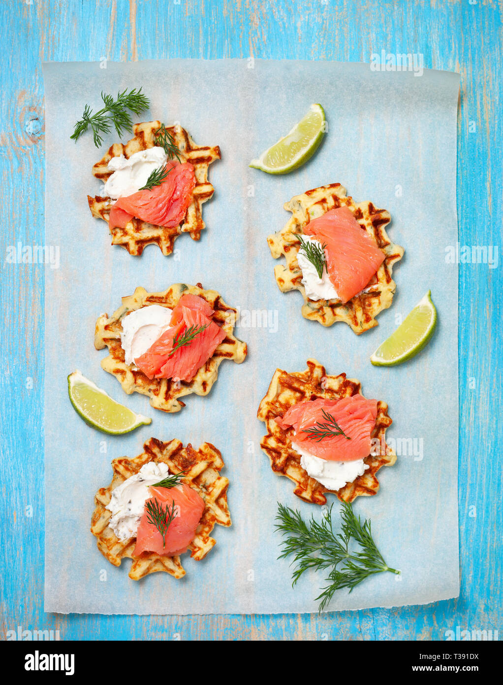 potato waffles with salmon, cream cheese on a blue wooden background. view from above Stock Photo