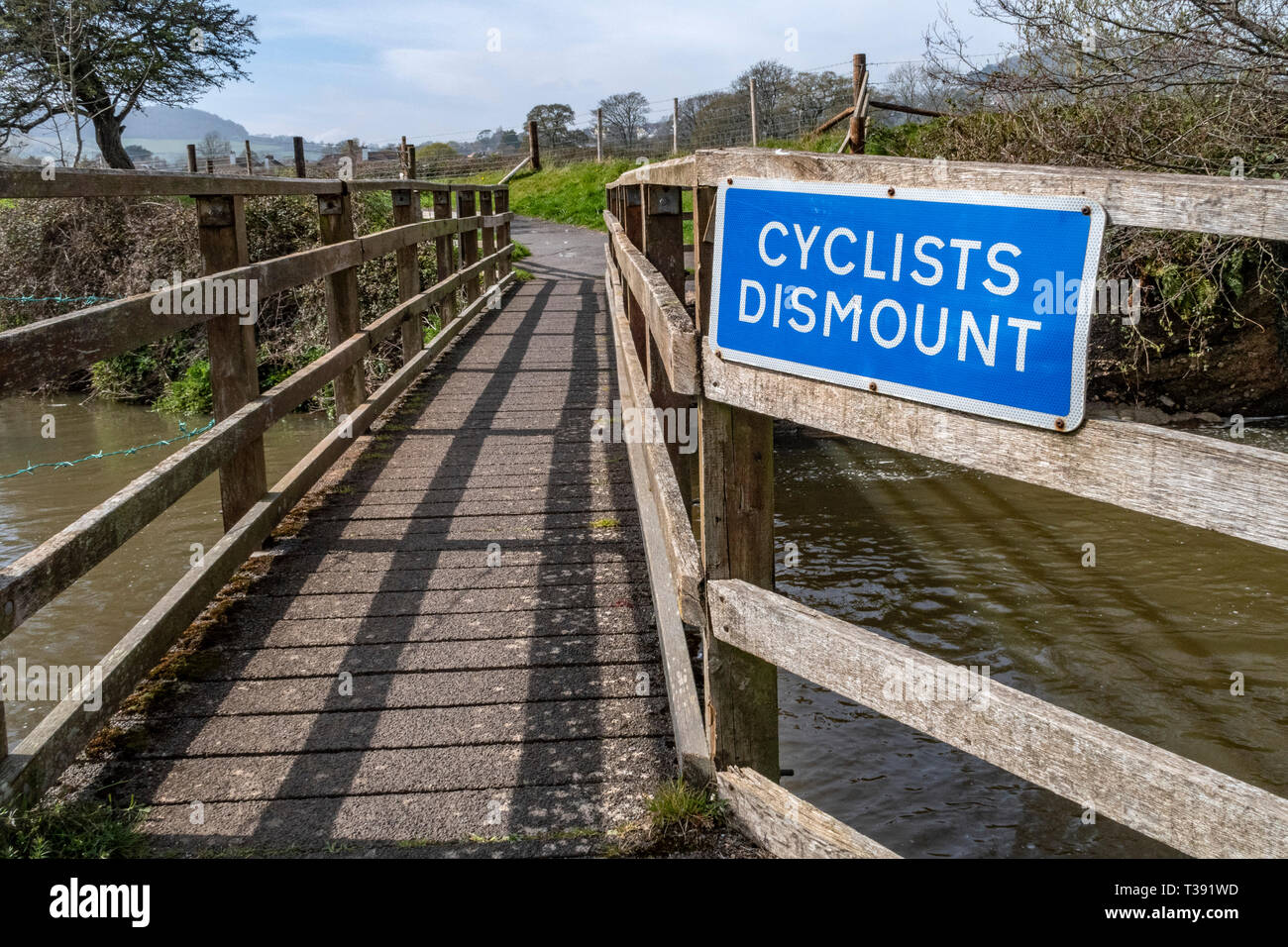 Cyclists Dismount sign notice on a footbridge over the River Sid at