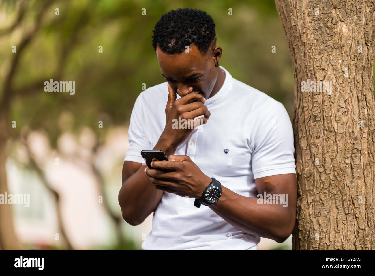 Outdoor portrait of a Young black African American men texting on ...
