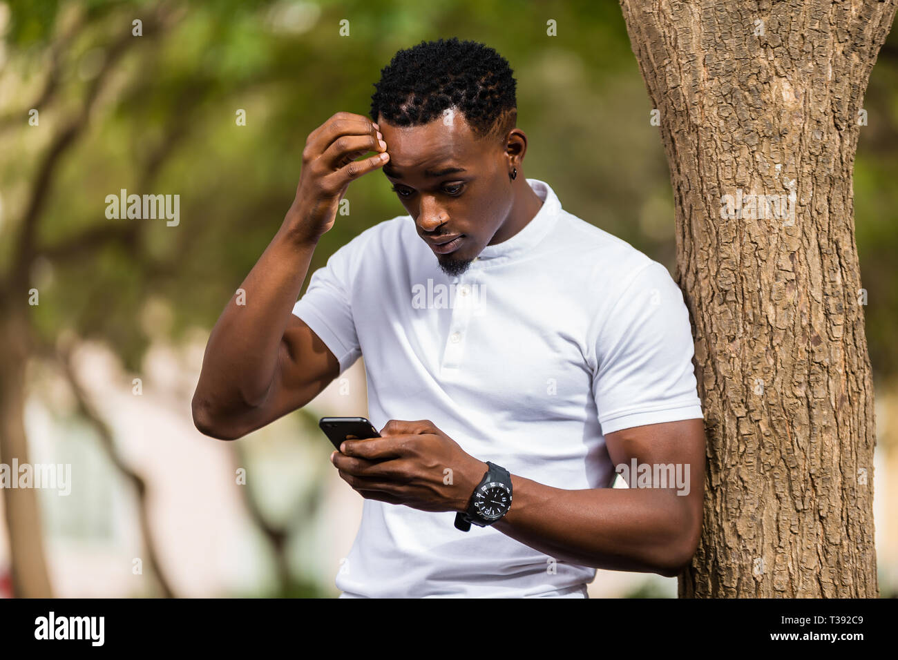 Outdoor portrait of a Young black African American men texting on ...