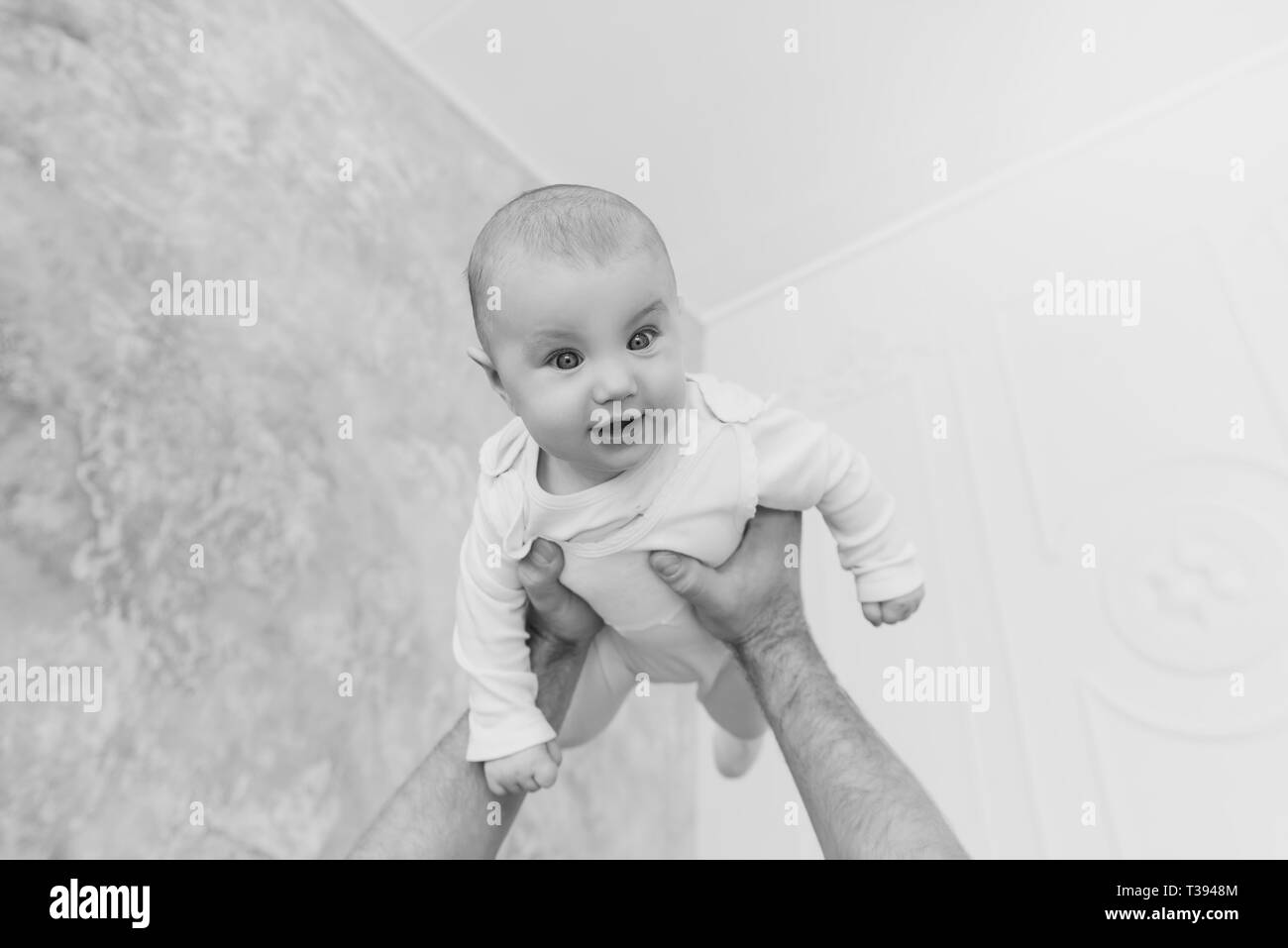 Flying baby in strong male father hands Stock Photo