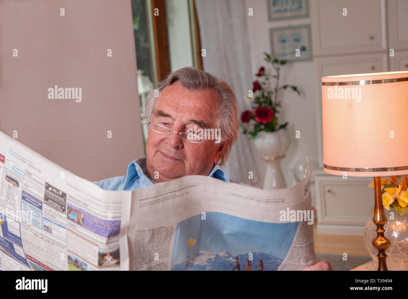 Senior with glasses reading newspaper Stock Photo