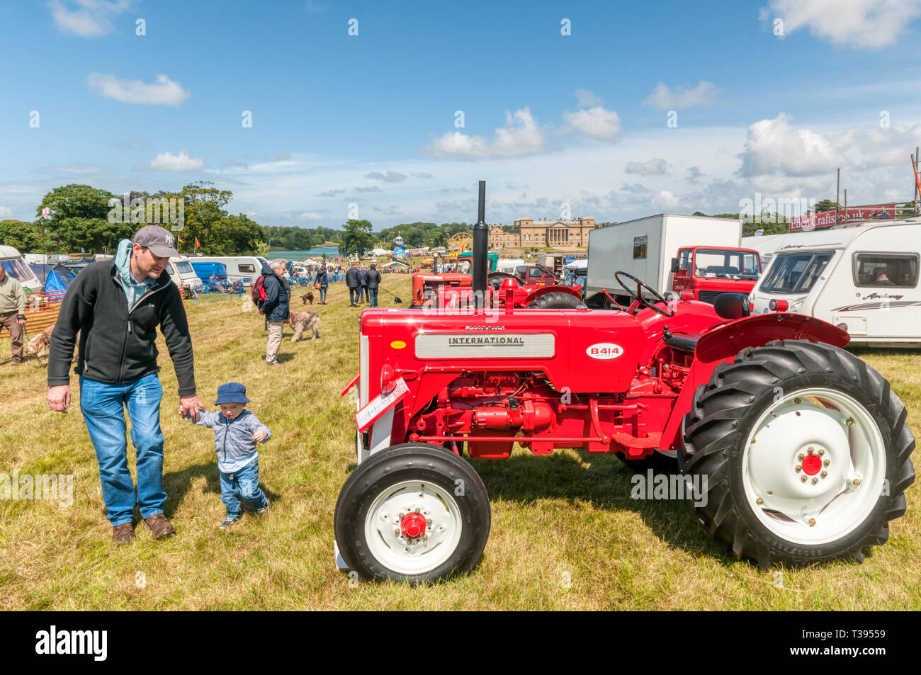 A father & son looking at tractors at the Holkham Country Fair in the grounds of Holkham Hall in North Norfolk. Stock Photo