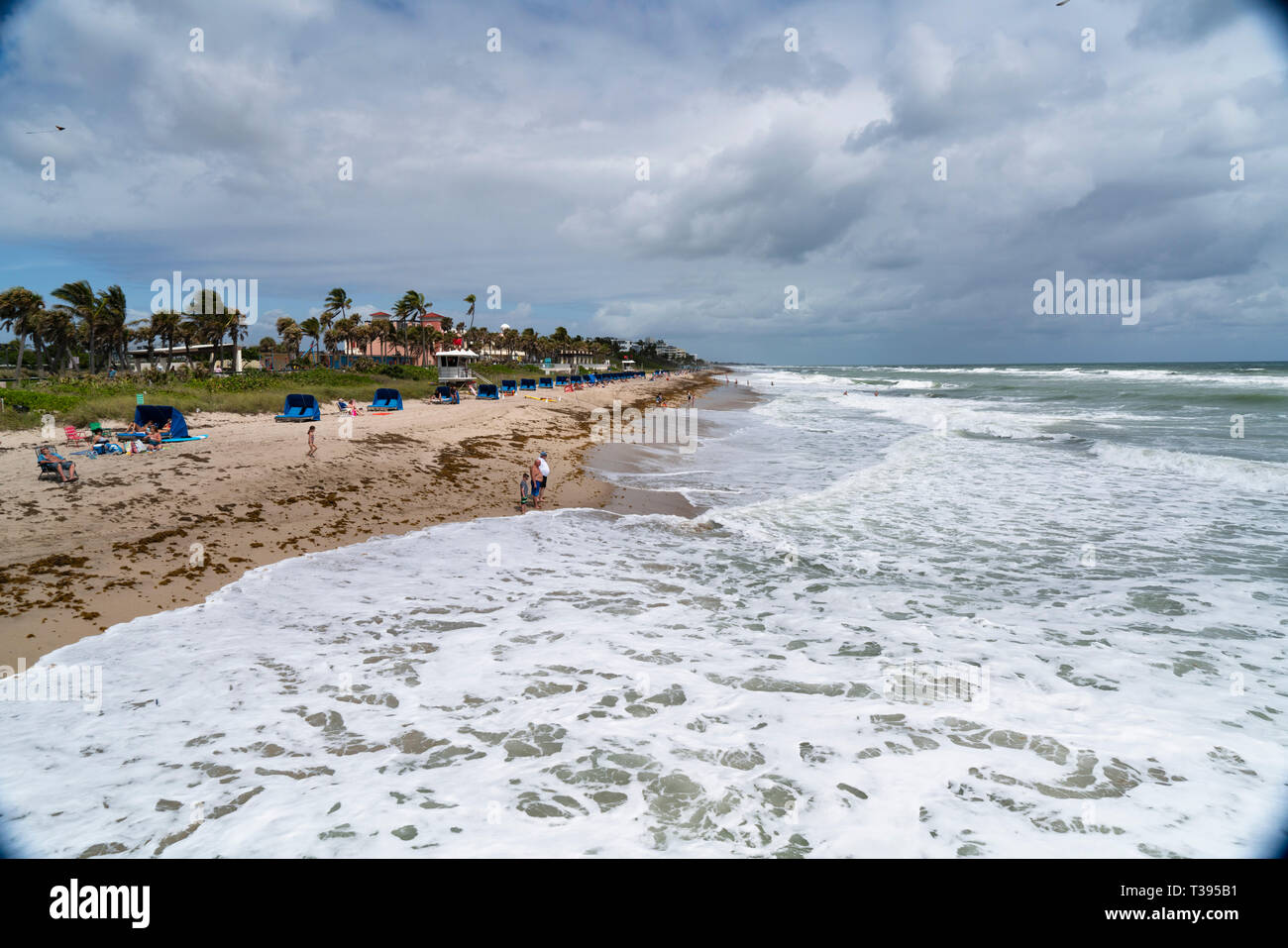 Lake Worth Florida on a high surf day. Red flags and no swimming flags are out. People are still in the water. Stock Photo