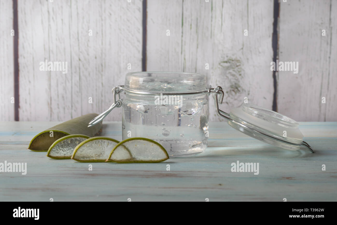 Natural Aloe Vera gel in glass jar, on a light wooden background. View from the front Stock Photo