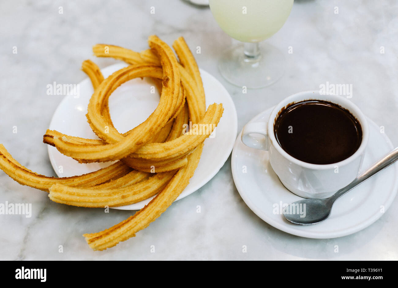 A plate of traditional hot, fried churros with hot chocolate in Madrid