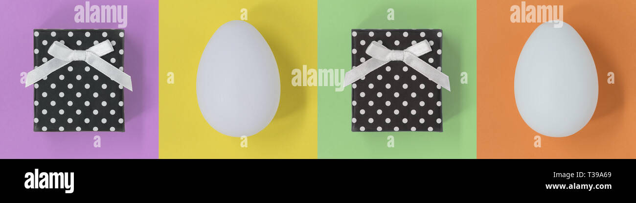Easter eggs and gift boxes on a multicoloured square background, banner Stock Photo