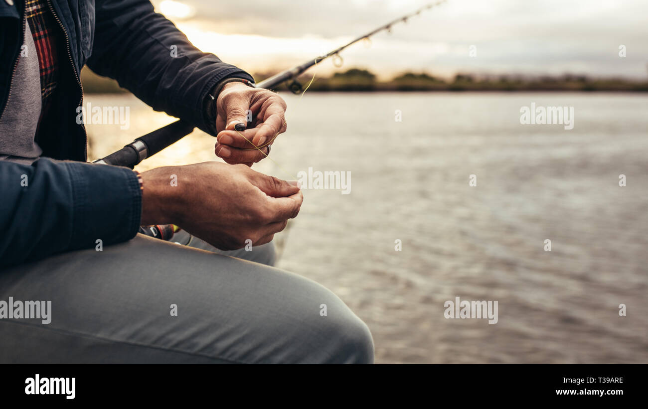 Close up of a person sitting beside a lake getting ready to catch a ...