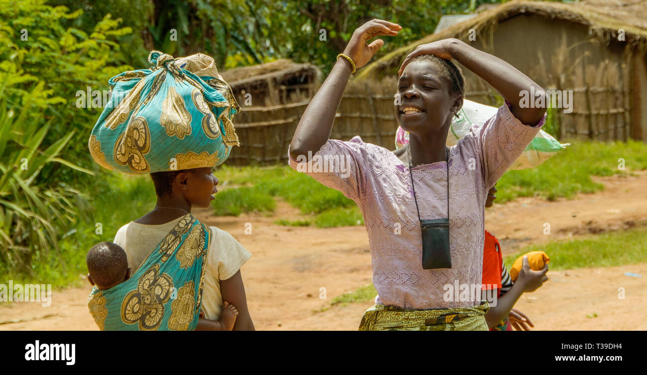 Malawian woman holding her hair with a mobile phone around her neck in Chiphazi village Stock Photo