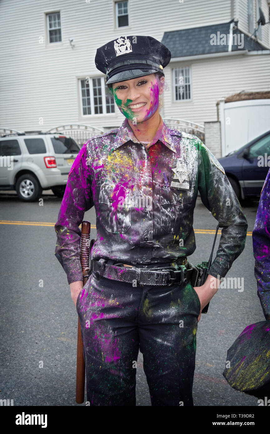 A beautiful auxiliary Policewoman covered in colored powder at the Holi Parade in Richmond Hill, Queens, New York City Stock Photo