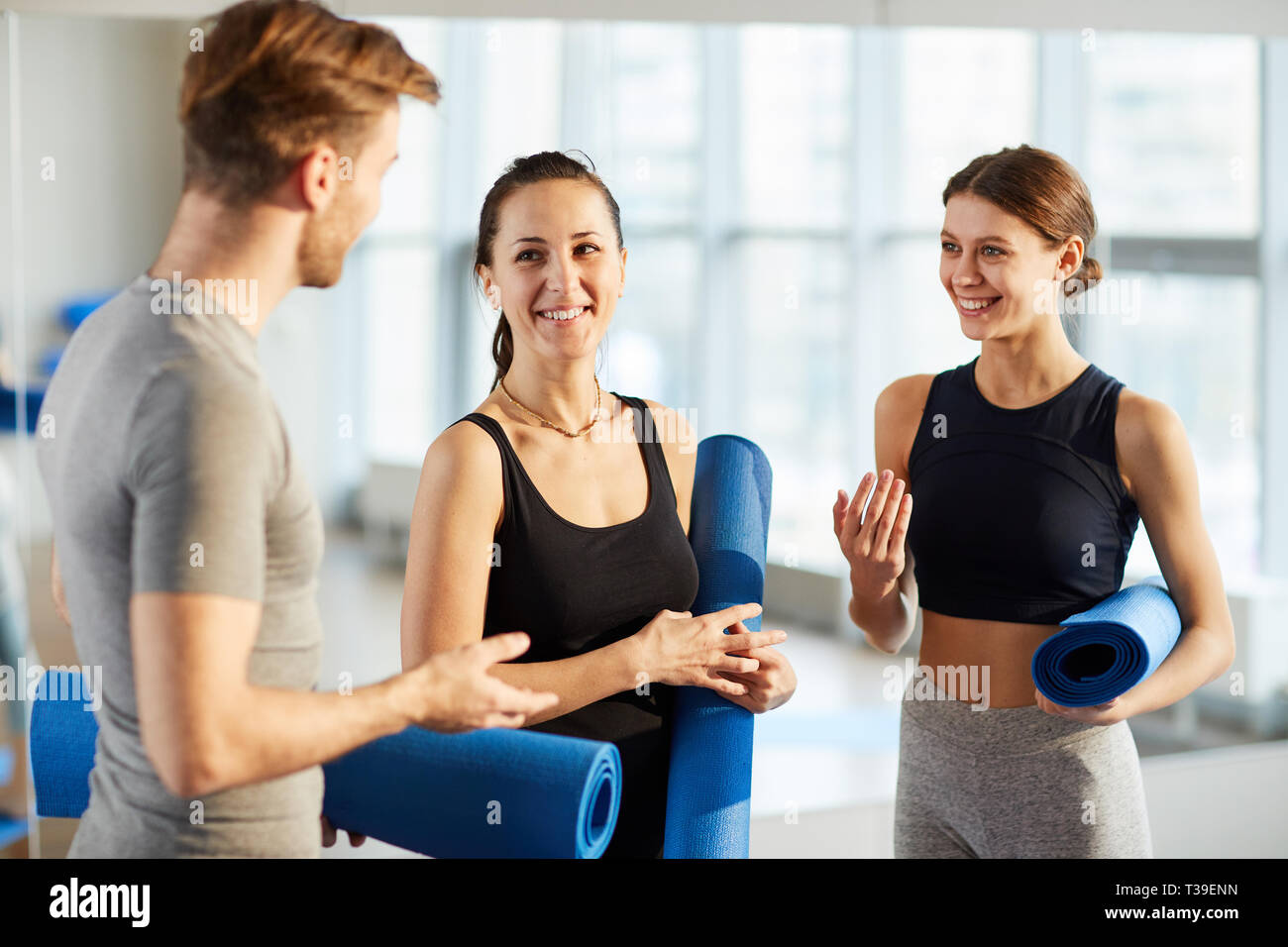 Yoga students discussing new exercises Stock Photo