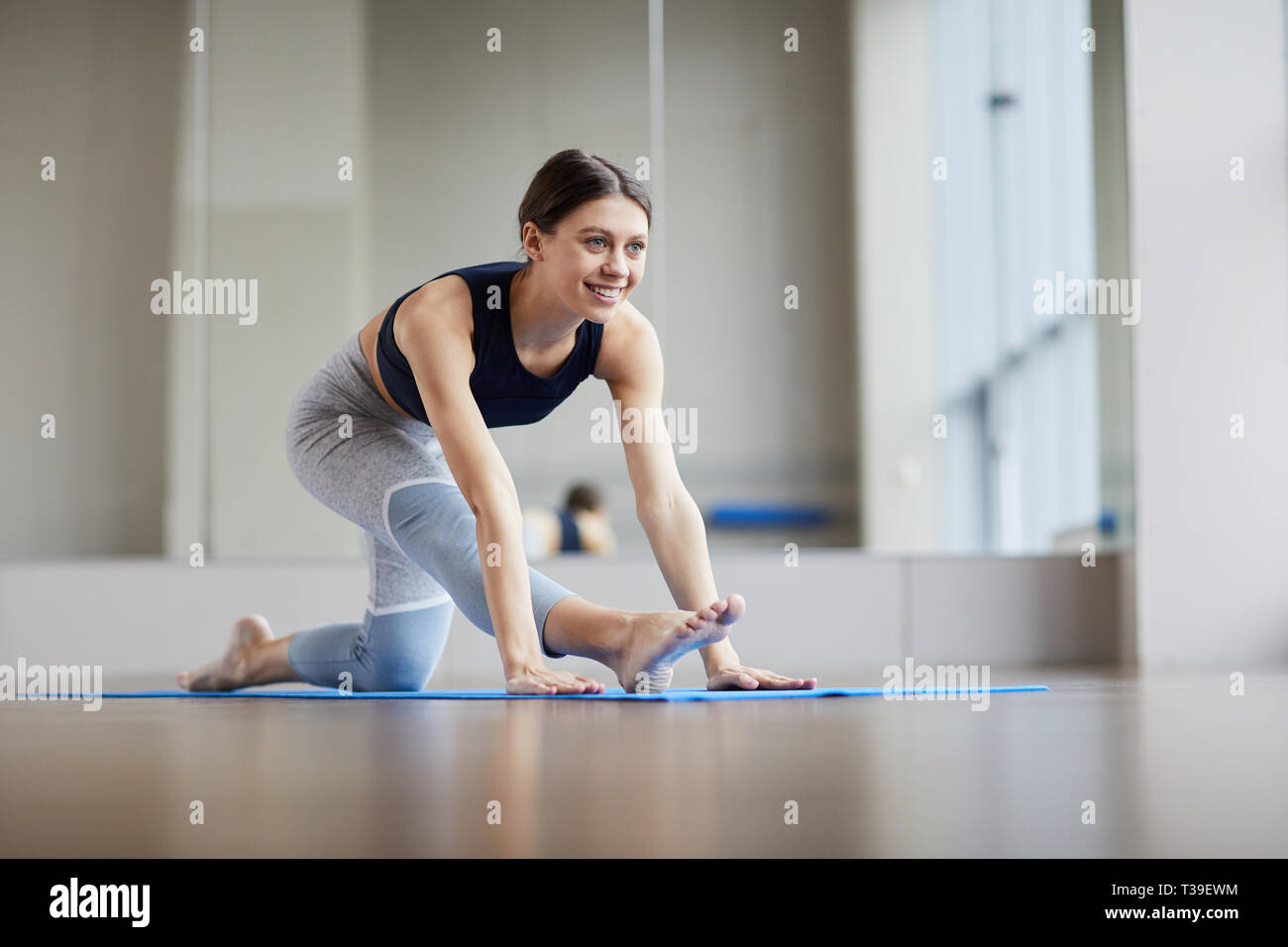 Cheerful woman stretching leg Stock Photo