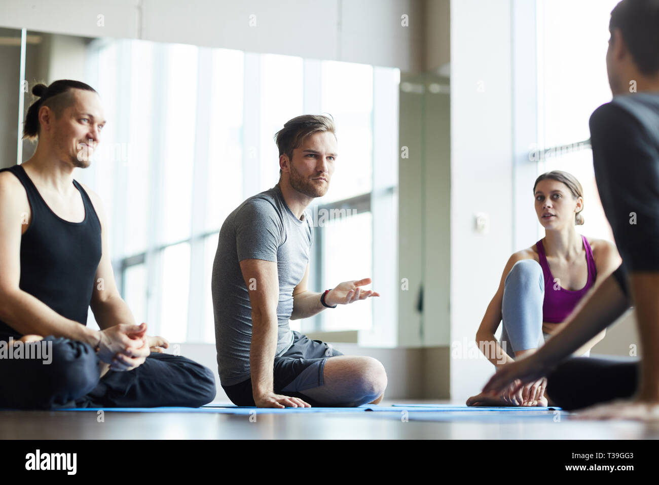 Students discussing training with yoga coach Stock Photo