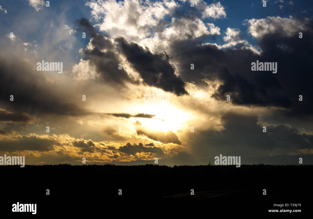 colorful golden sunset with blue sky and mighty clouds Stock Photo - Alamy