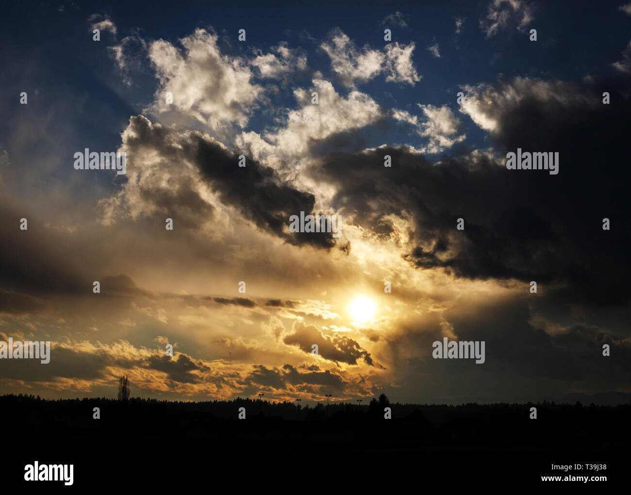 colorful golden sunset with blue sky and mighty clouds Stock Photo - Alamy