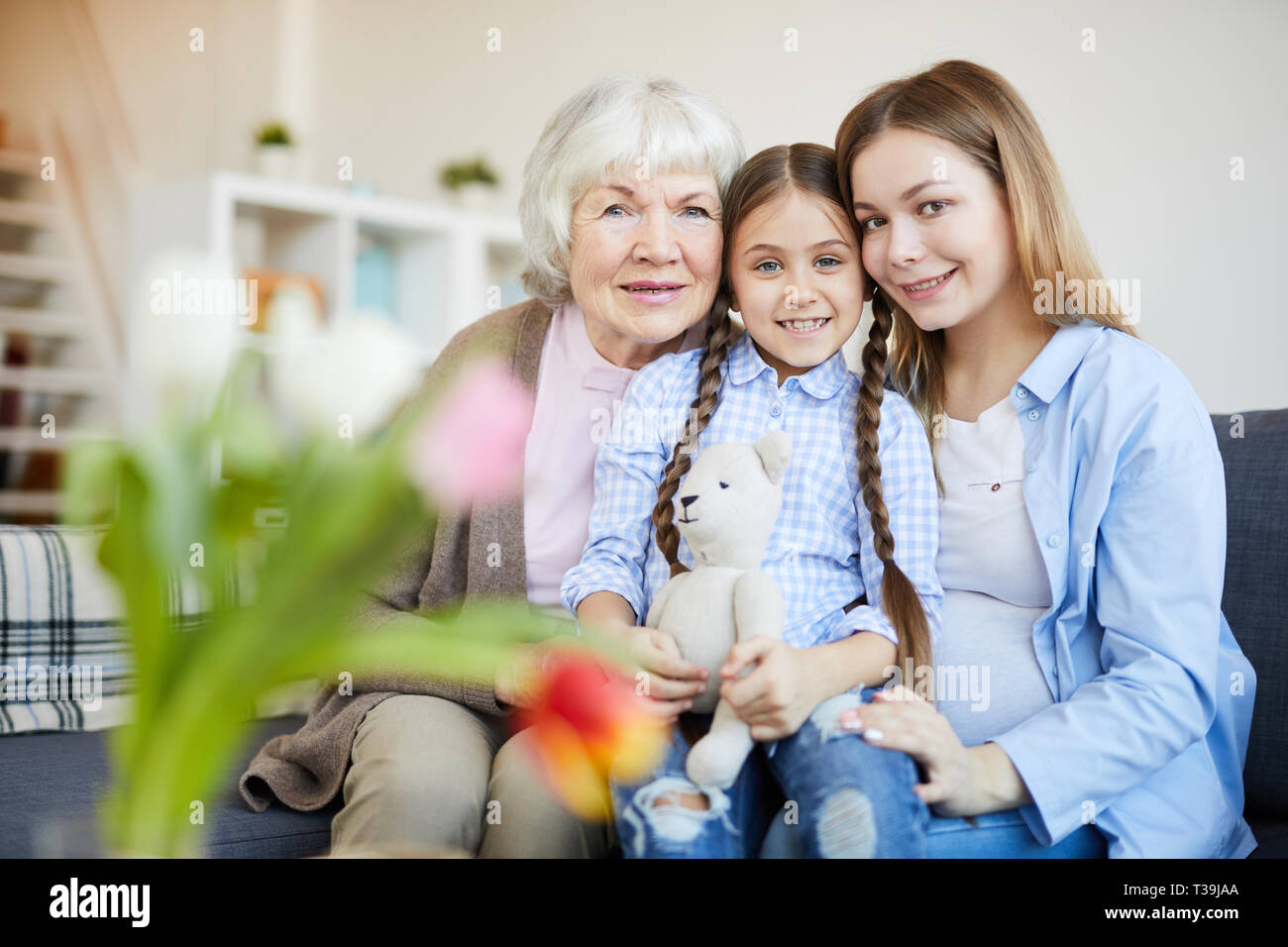 Beautiful Old Woman And Young Girl Are Hugging, Looking At Each Other And  Smiling While Sitting On Couch At Home Stock Photo, Picture and Royalty  Free Image. Image 63889002.
