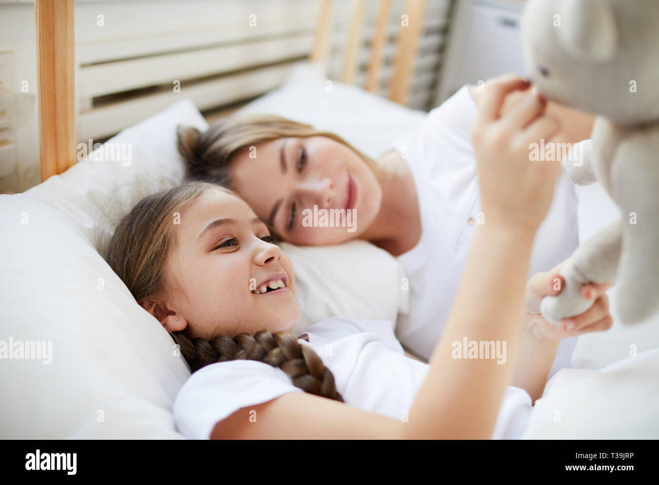 Mother and Daughter Lying in Bed Stock Photo