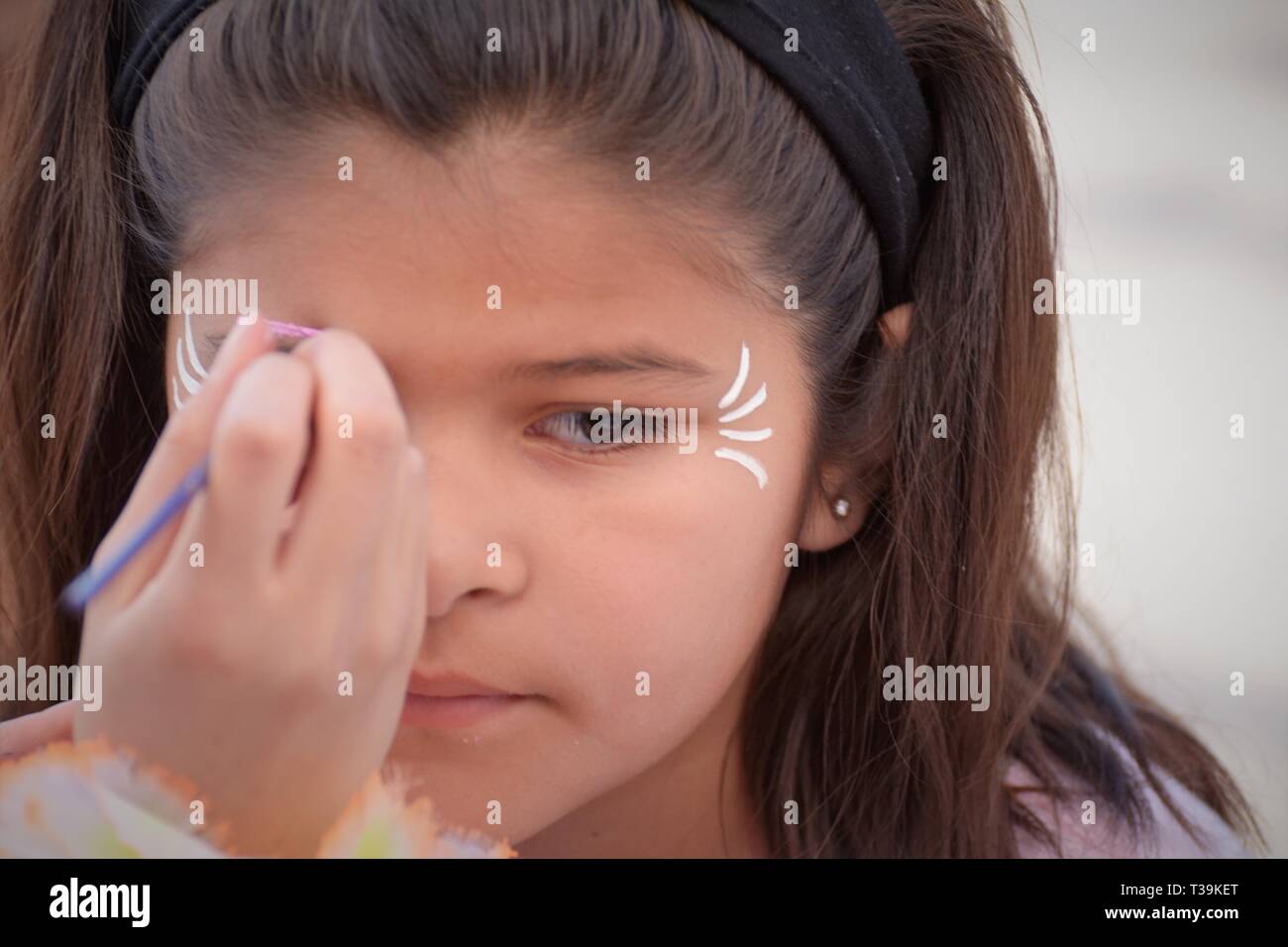 Latina girl having her face painted Stock Photo