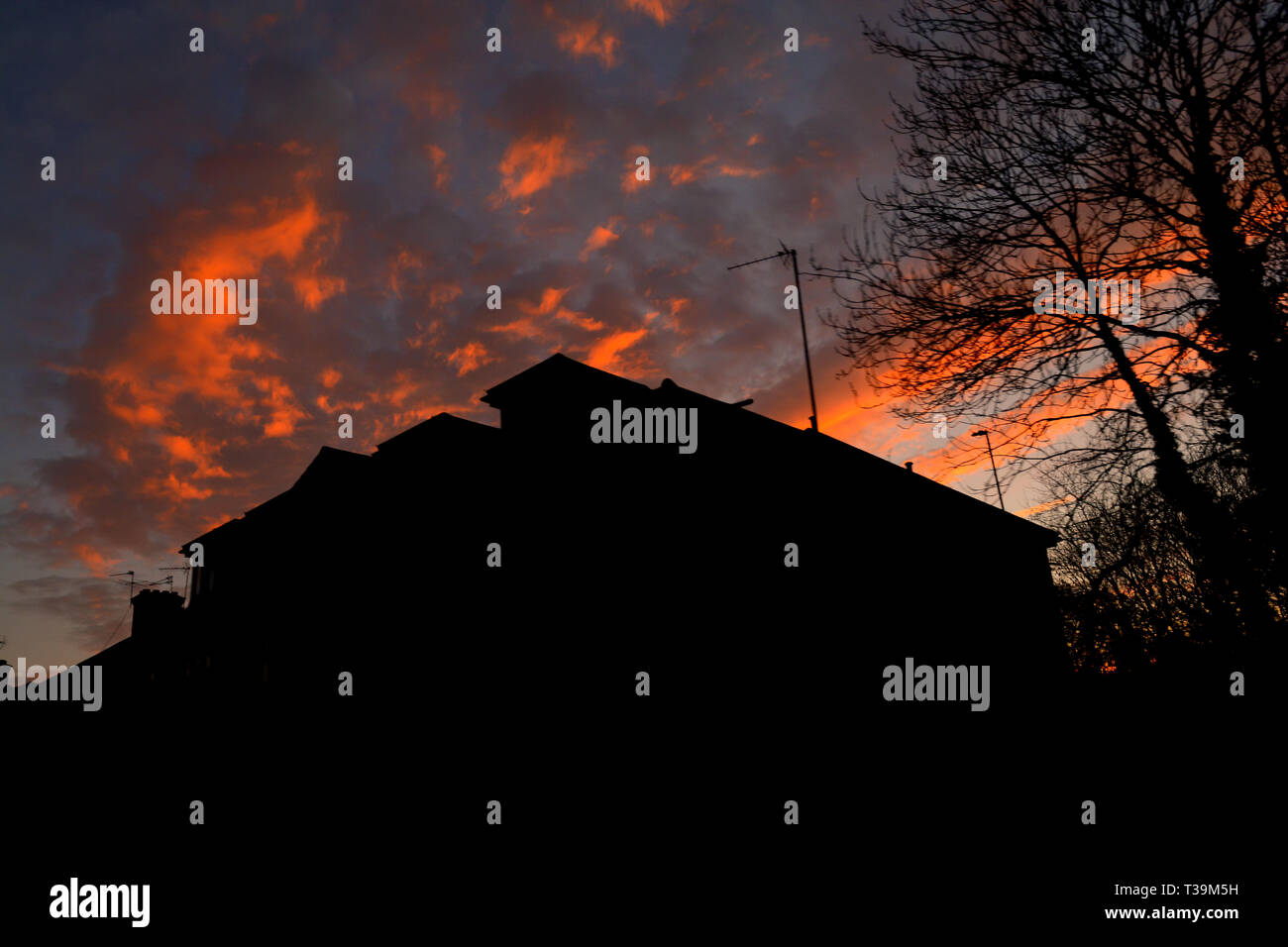 Sunset over buildings in built up suburb. Urban landscape Stock Photo
