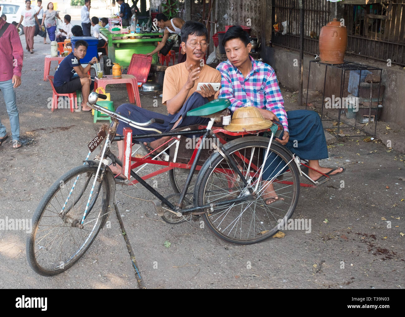 Bicycle rickshaw drivers having a break in  Yangon, Myanmar (Burma) Stock Photo