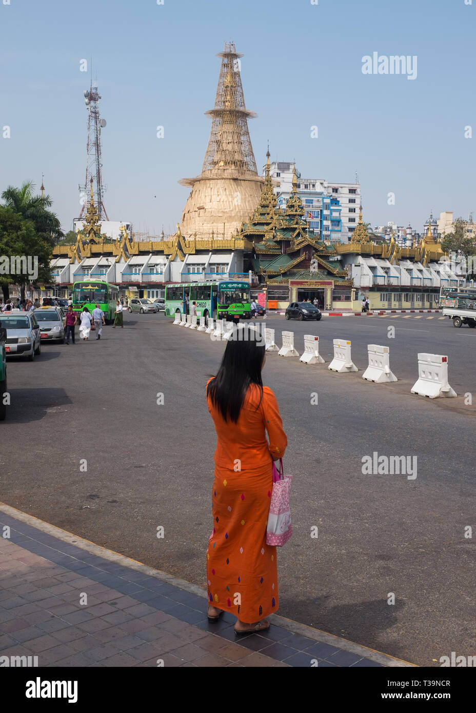 woman waiting at bus stand on  Sule Pagoda Roundabout , Yangon (Rangoon),Myanmar (Burma). Stock Photo