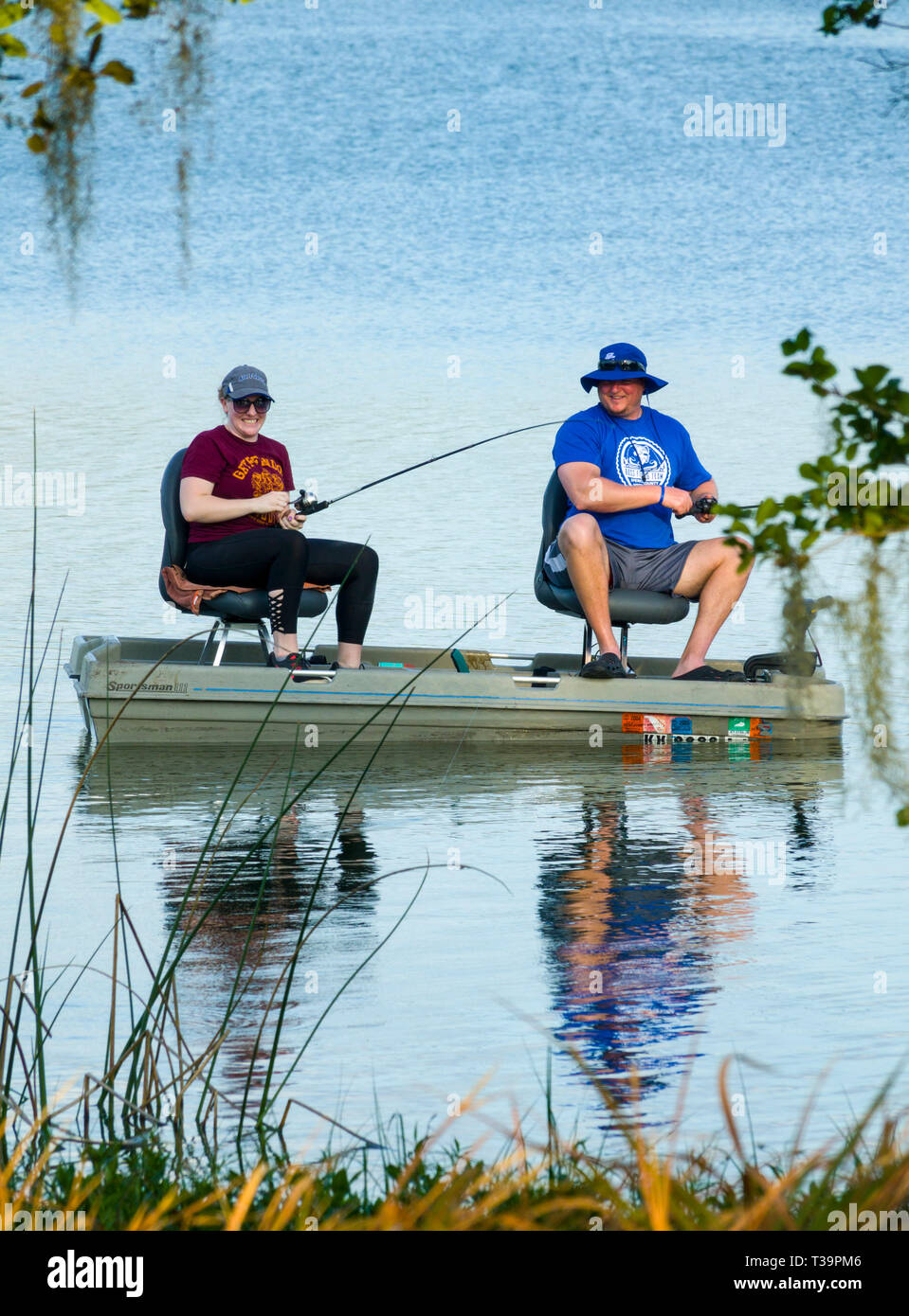 Husband and wife fishing from a small boat together for bass fish on Hardee Lake County Park Florida campground Stock Photo