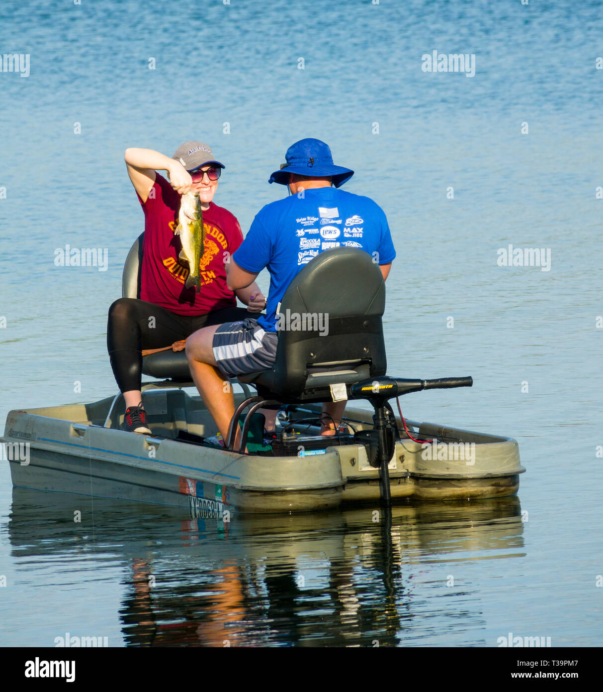 Husband and wife fishing from a small boat together for bass fish on Hardee Lake County Park Florida campground Stock Photo