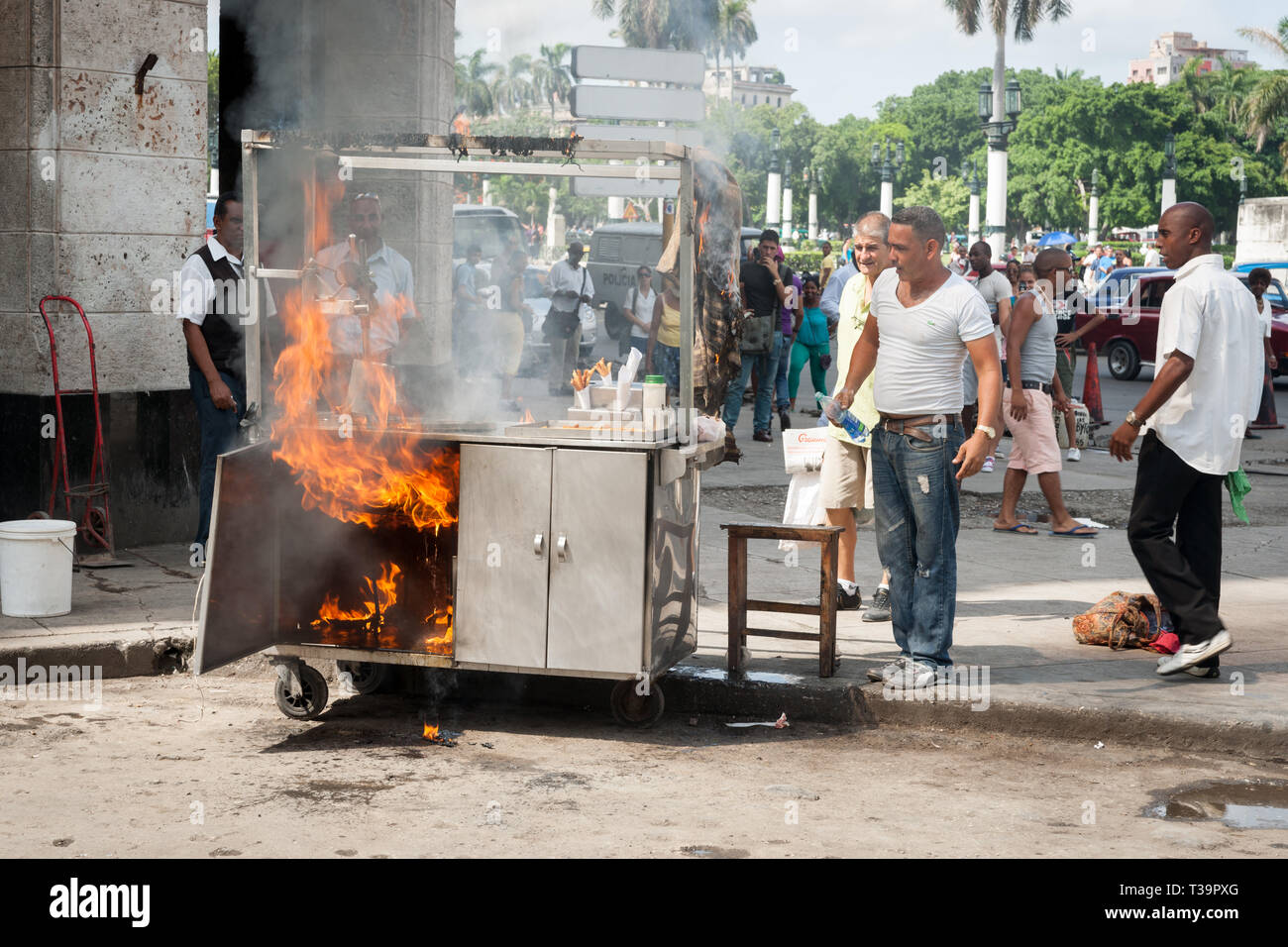 HAVANA CUBA - JULY 7 2012; Food trolley catches fire in city street whiole people staround watching. Stock Photo