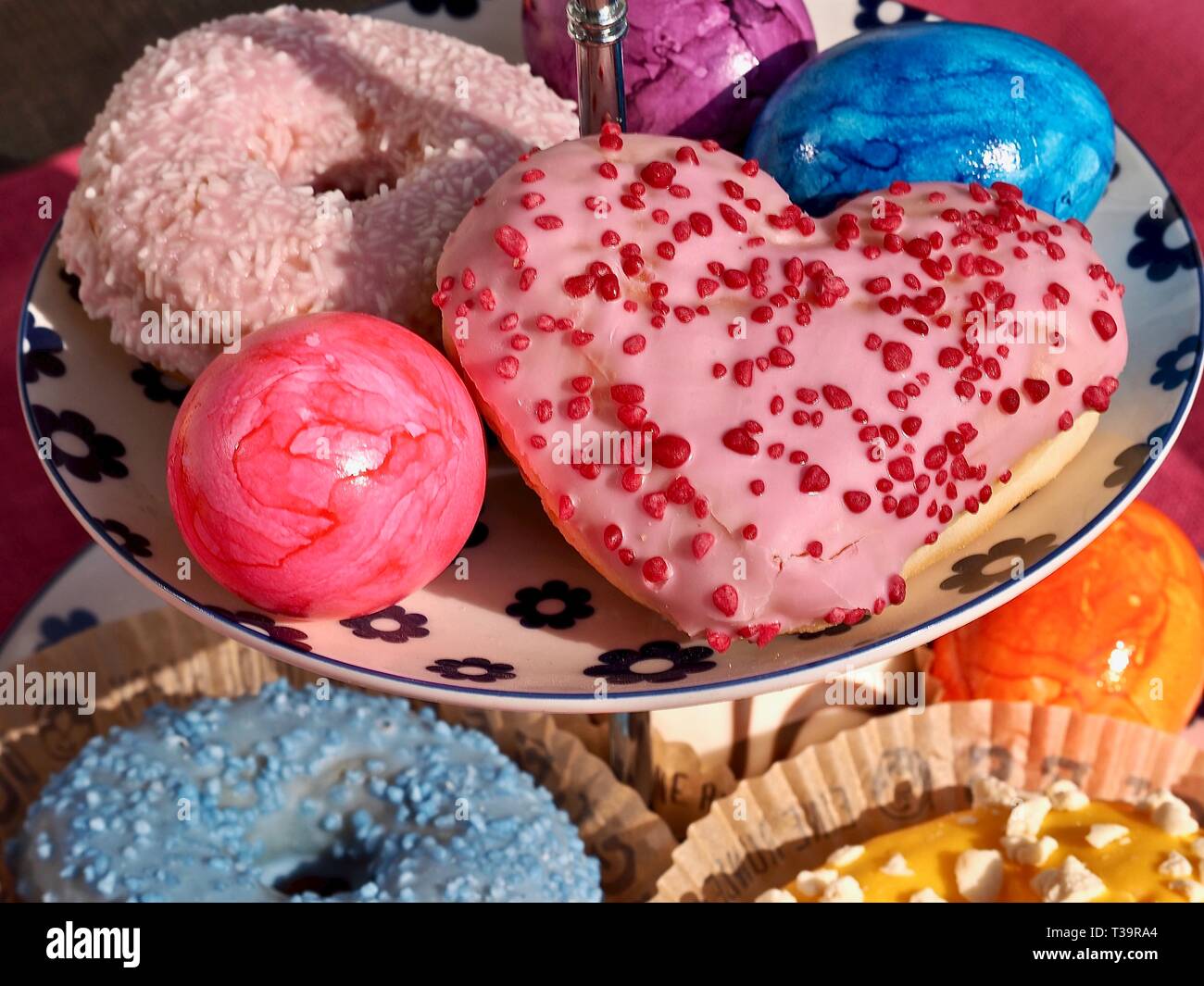 Arrangement of colorful doughnuts and easter eggs Stock Photo
