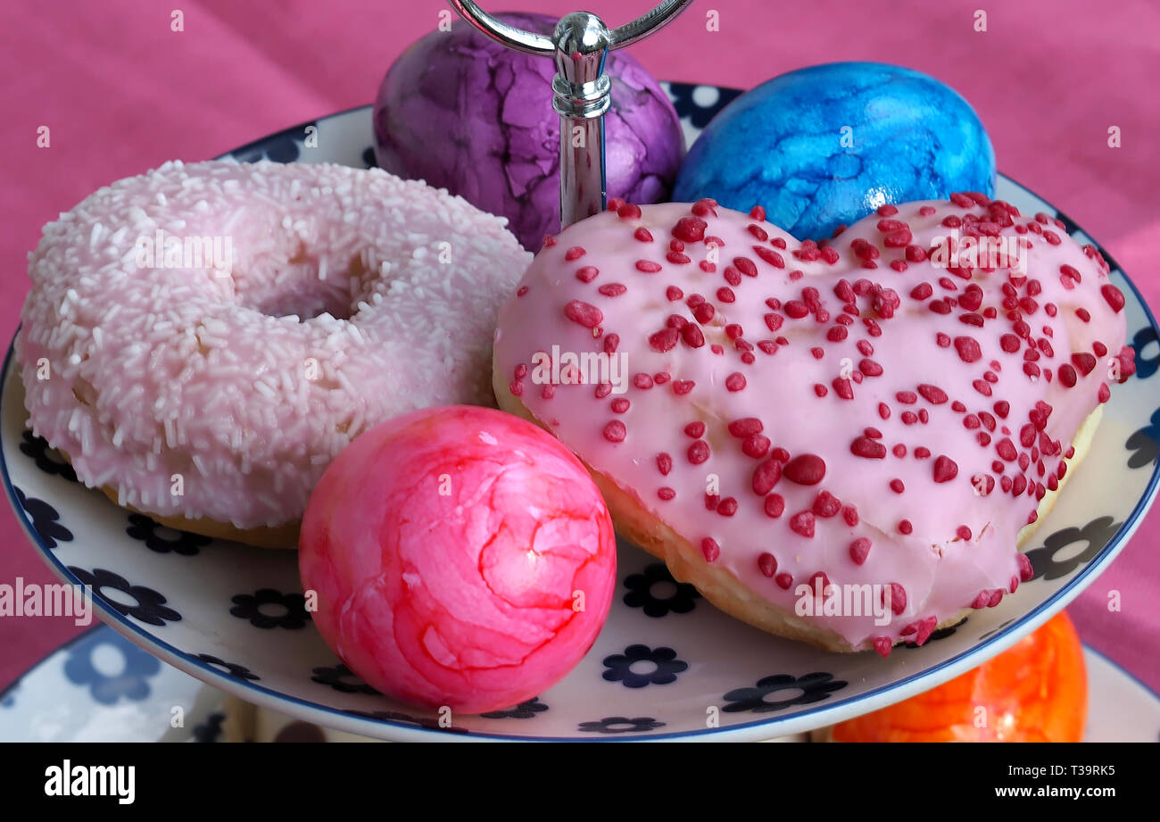 Arrangement of colorful doughnuts and easter eggs Stock Photo