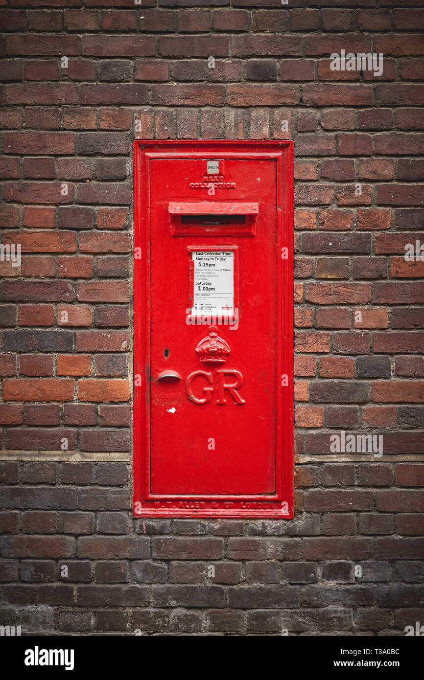 Cambridge, UK - December, 2018. An old red Royal Mail post box in a brick wall. Stock Photo