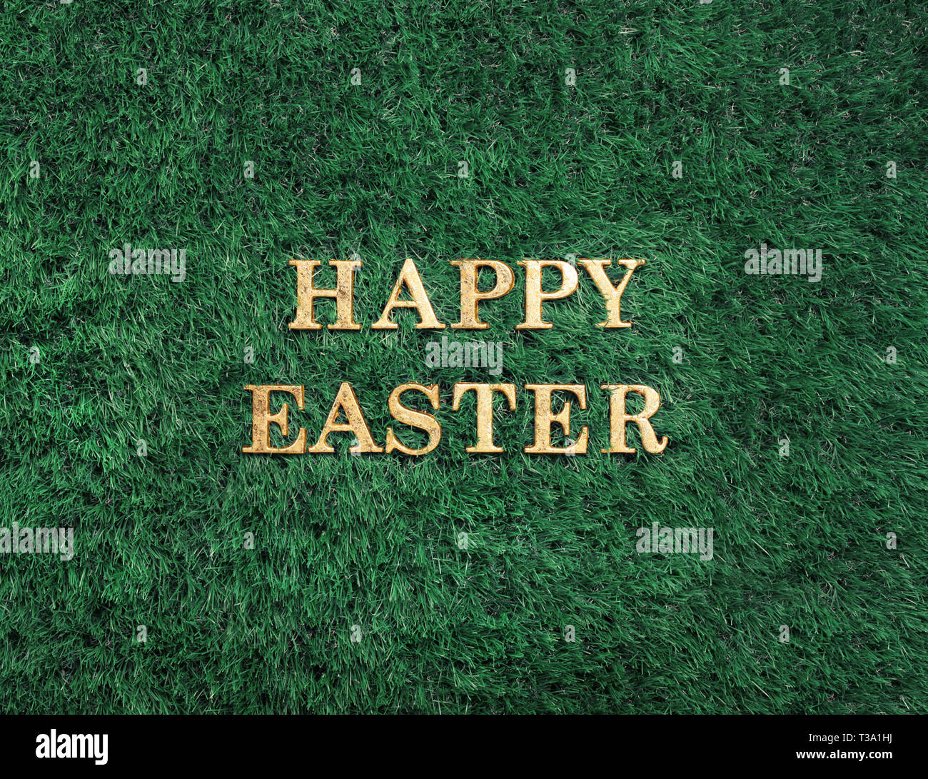 Happy Easter gold text laying in green grass Stock Photo