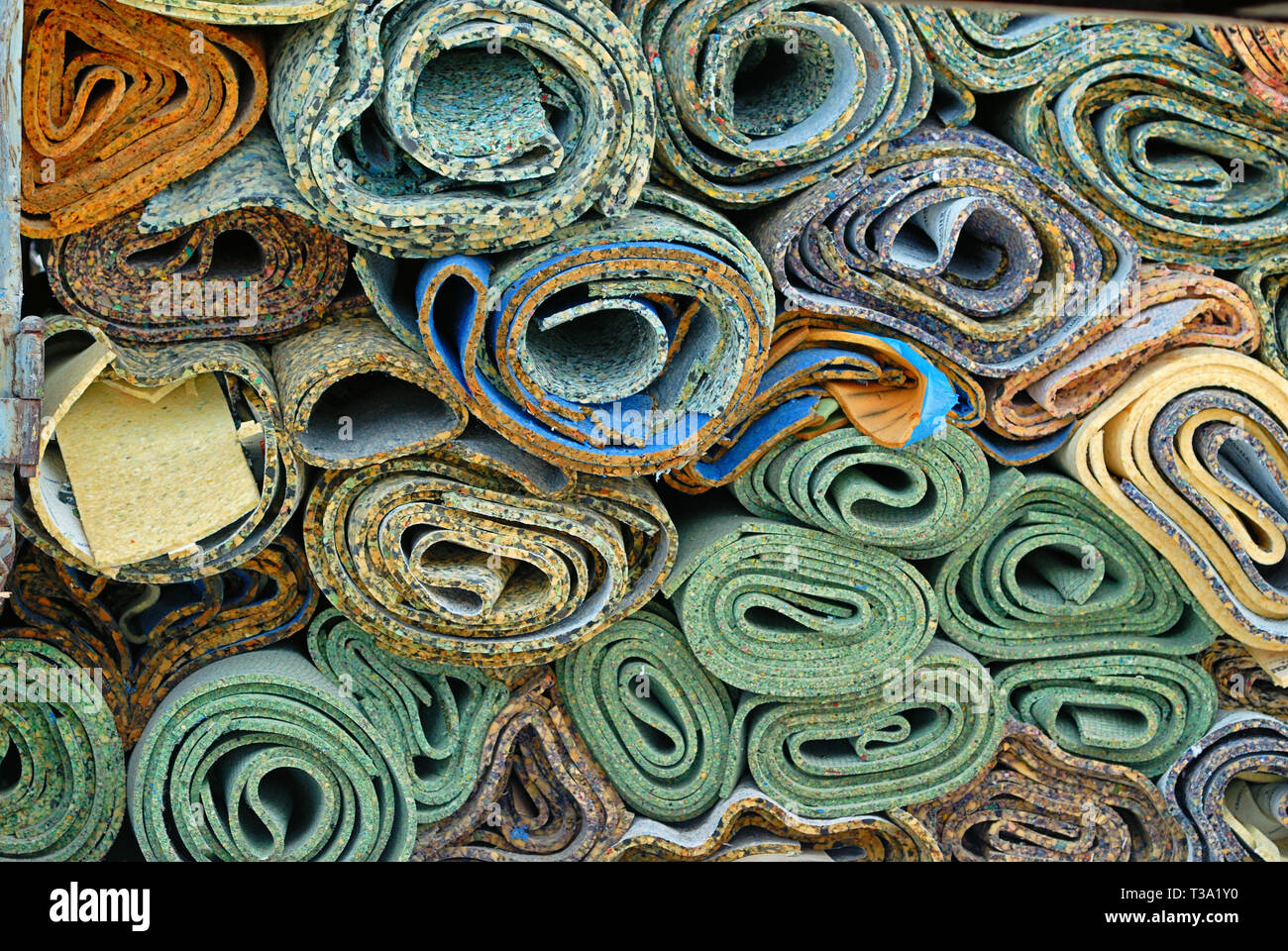 A stack of old carpet padding rolls Stock Photo - Alamy