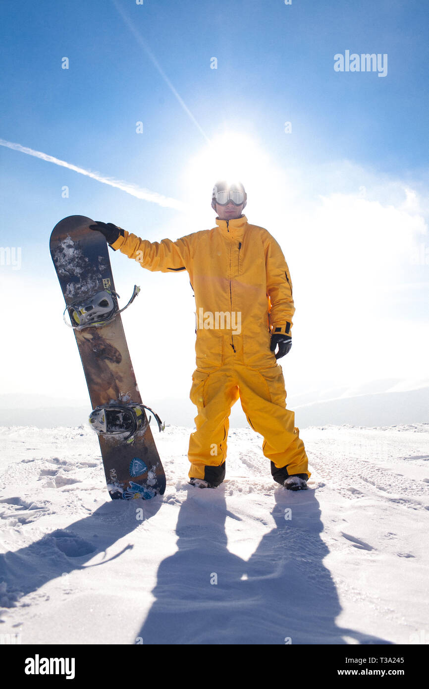 professional snowboarder standing with snowboard in the mountains. Beautiful mountain landscape in the background. Photo on a theme of extreme sports Stock Photo
