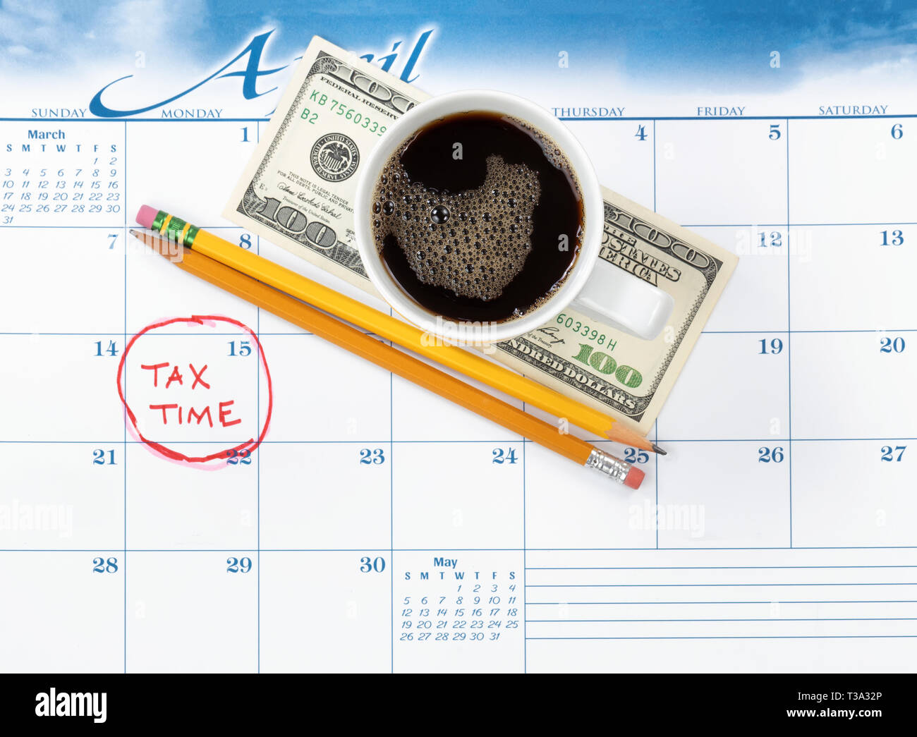 Tax due date marked on calendar with pencils and coffee on top Stock