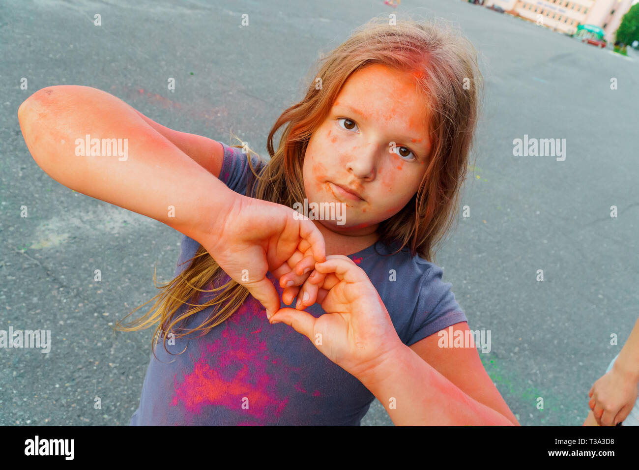 Happy young girl covered with colorful dry paint at Holi festival Stock Photo