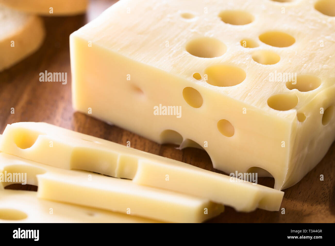 Piece of Emmental, Emmentaler or Emmenthal cheese on wooden plate