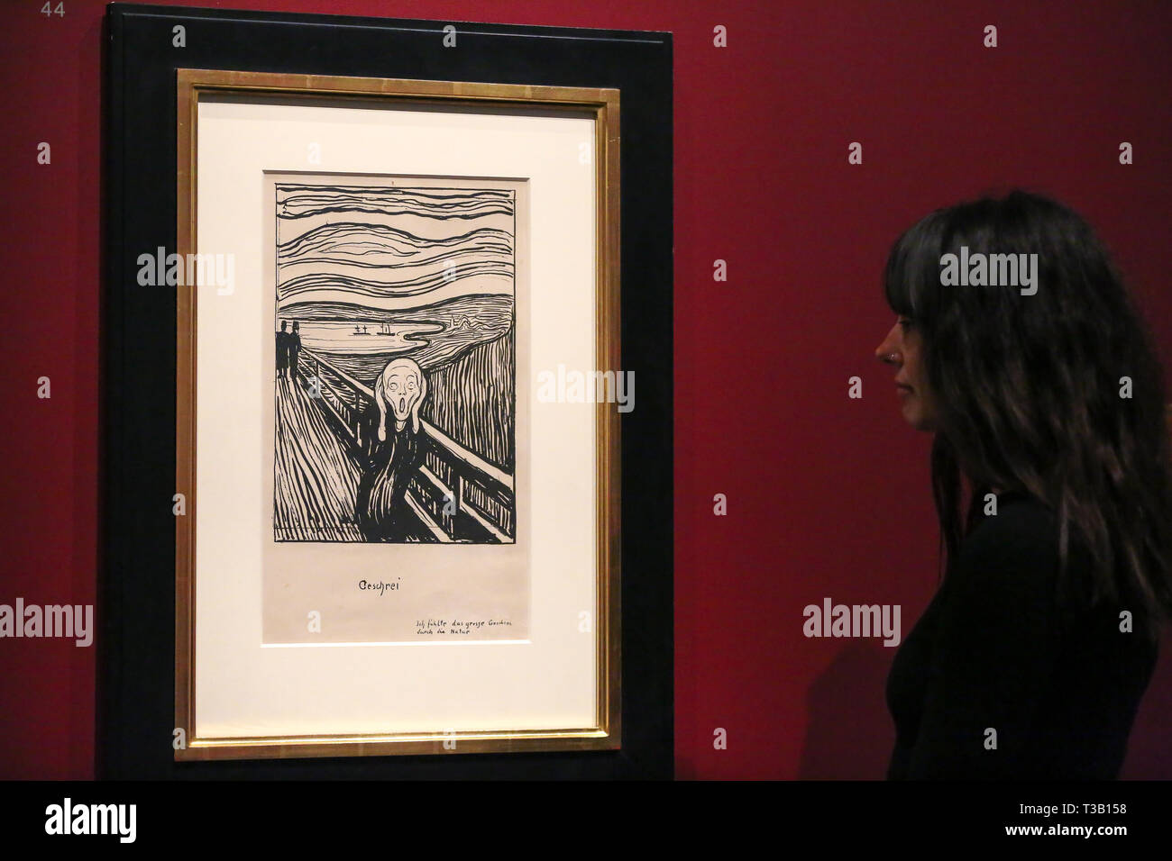 The British Museum. London, UK 8 April 2019 - A staff member views Edvard Munch's “The Scream, 1895” - which developed from an episode represented in Despair, but with the central figure turned to face the viewer. The swirling reddish-blue clouds are translated in this print into compressed undulating bands of black and white that emphasise the acute panic expressed by the figure. In a twist of fate, Munch's sister Laura was diagnosed in 1894 with schizophrenia and institutionalised in a hospital near the site of The Scream. Credit: Dinendra Haria/Alamy Live News Stock Photo