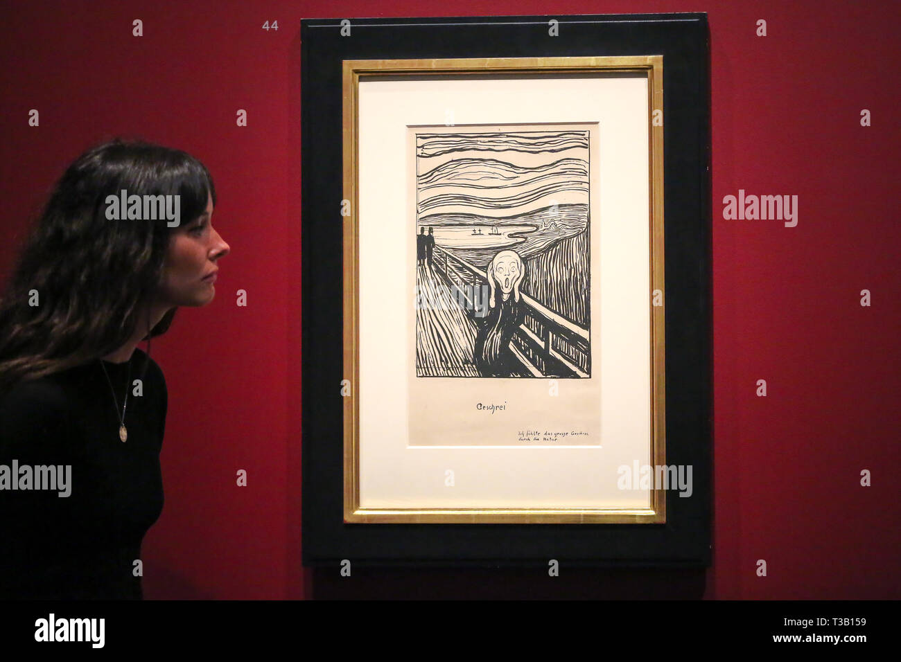 The British Museum. London, UK 8 April 2019 - A staff member views Edvard Munch's “The Scream, 1895” - which developed from an episode represented in Despair, but with the central figure turned to face the viewer. The swirling reddish-blue clouds are translated in this print into compressed undulating bands of black and white that emphasise the acute panic expressed by the figure. In a twist of fate, Munch's sister Laura was diagnosed in 1894 with schizophrenia and institutionalised in a hospital near the site of The Scream. Credit: Dinendra Haria/Alamy Live News Stock Photo