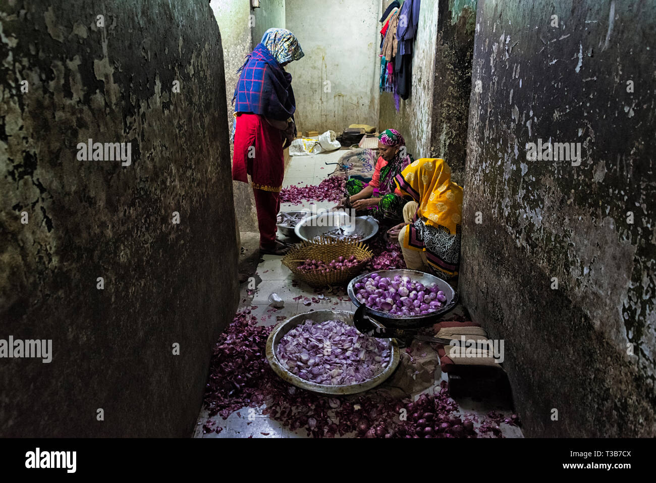 Woman peeling onions at a restaurant, Dhaka, Bangladesh Stock Photo