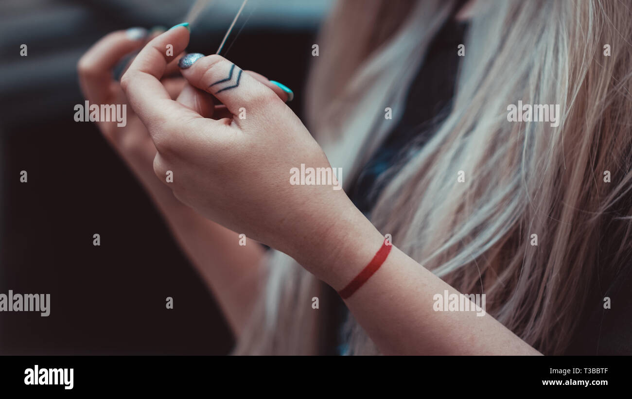 Womens hands with Arrows on the fingers, red line on the wrist - tattoos. Hipster style Stock Photo