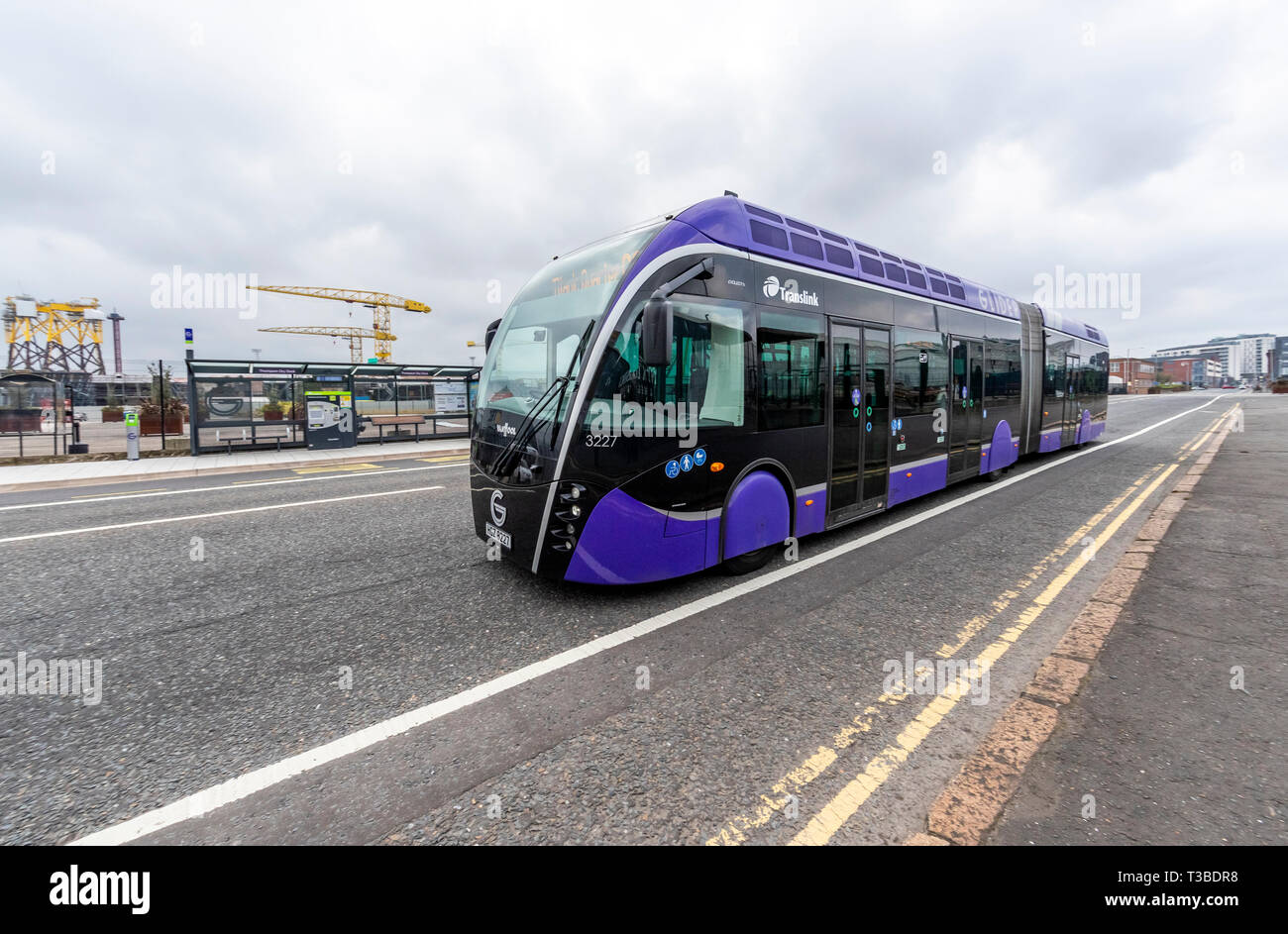 Belfast Glider bus. Modern sleek "bendy bus" as public transport passing Titanic Studios