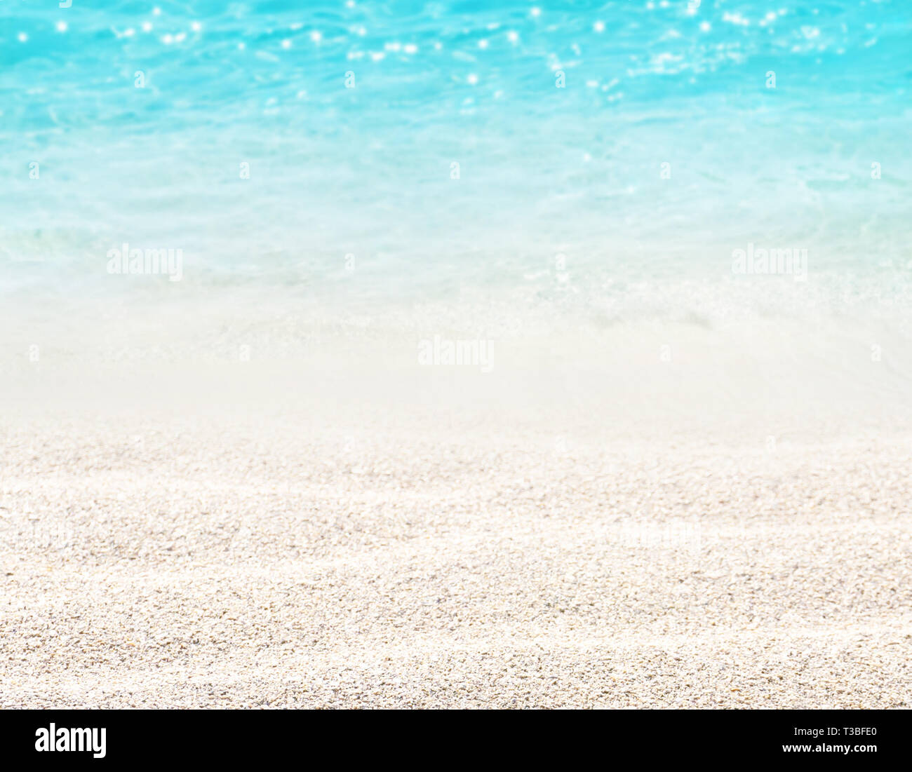 Beach blurred background. Sandy shore washing by the wave. Dreams summer vacations destination. Crystal clear sparkling sea. Stock Photo